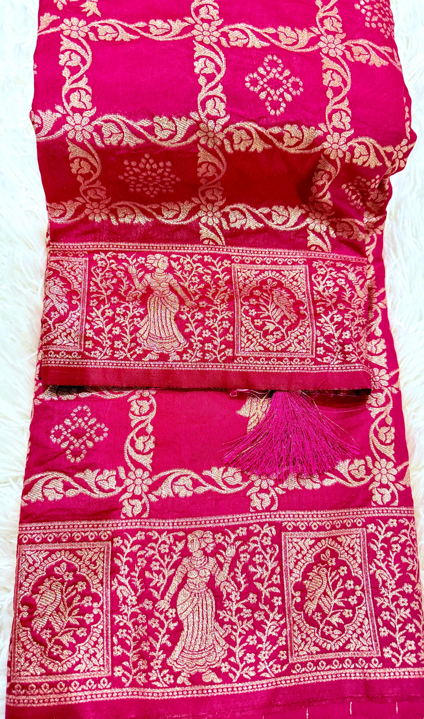 Pink and white patterned fabric with tassels on a white background