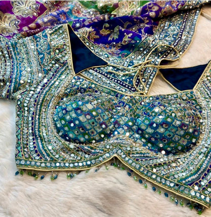 Decorative fabric with intricate patterns and embellishments on a textured surface