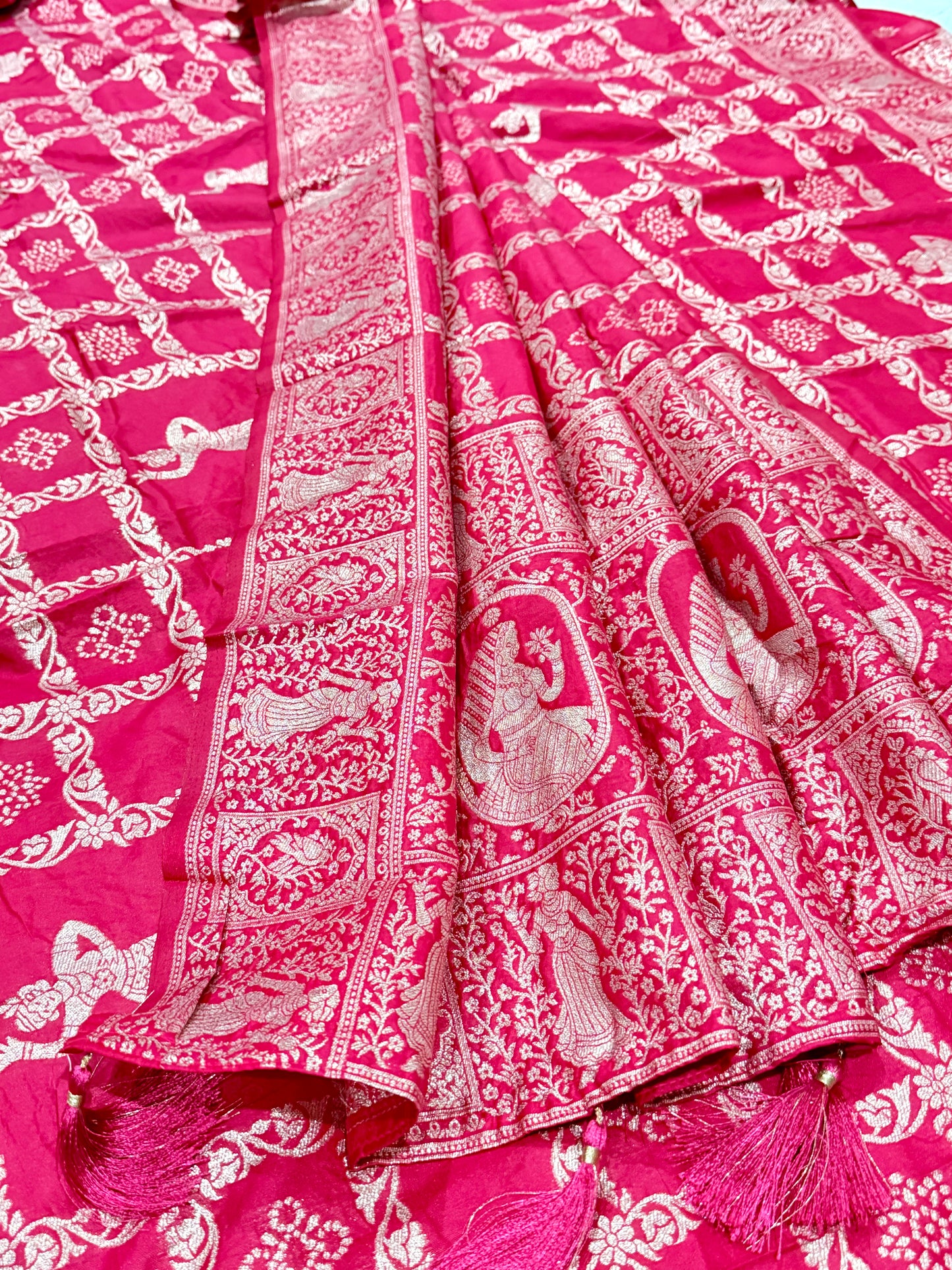 Pink saree with white patterns on a matching pink background