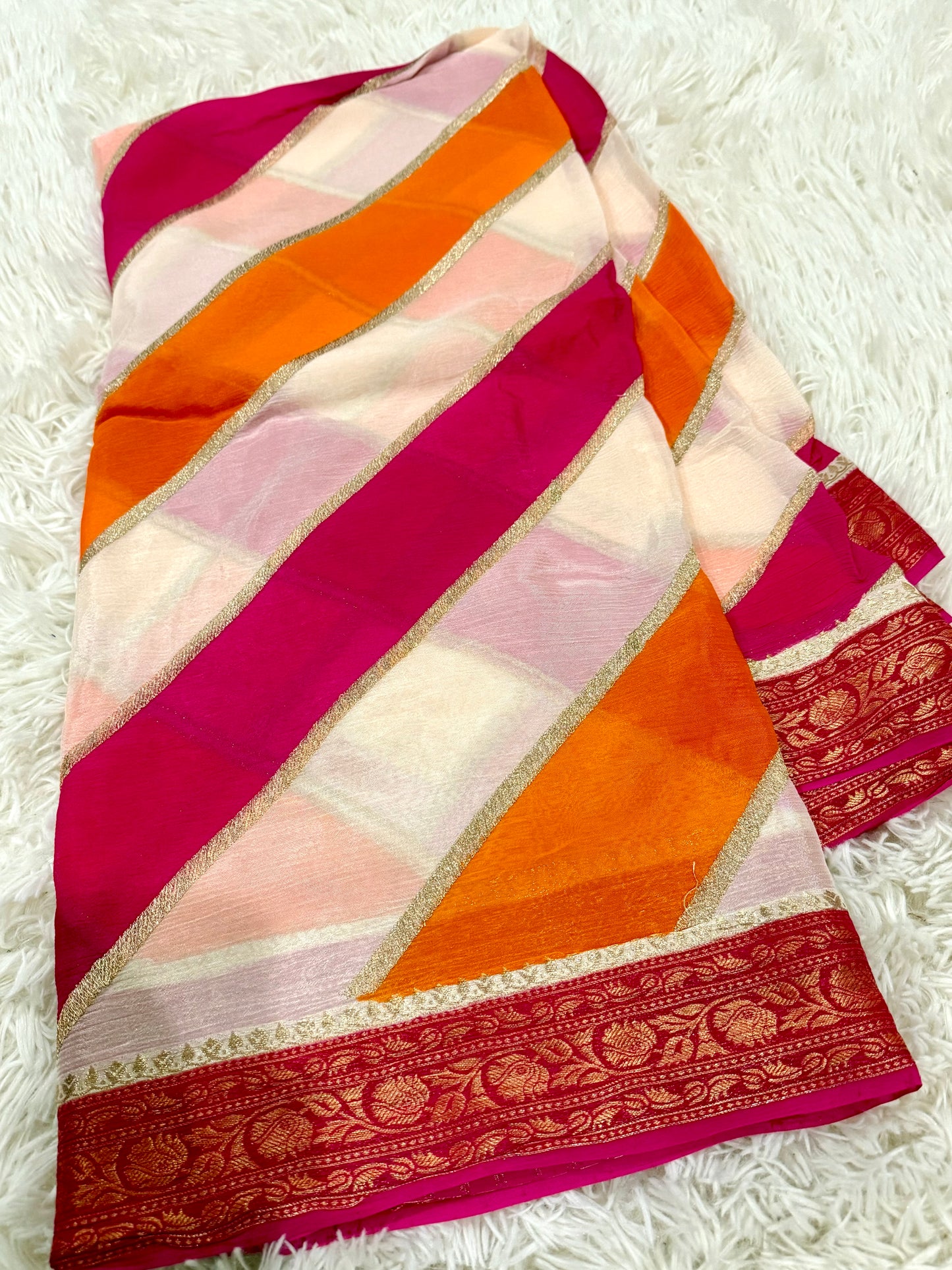 Colorful fabric with pink, orange, and white stripes on a white textured background