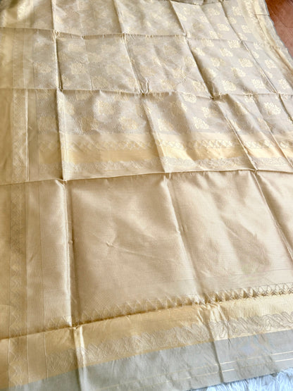 Beige fabric with a subtle pattern, possibly a sari or a similar type of textile.