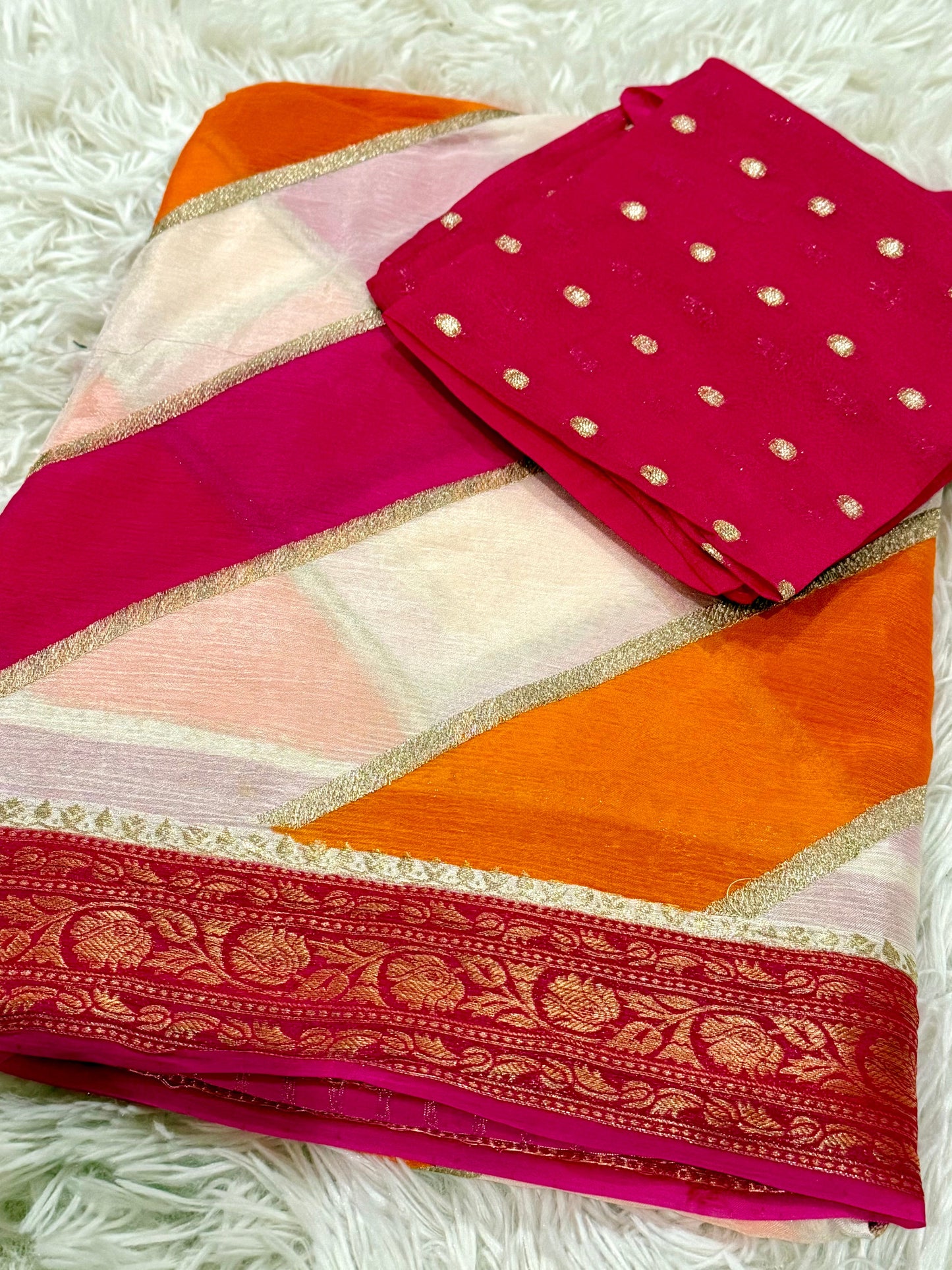 Saree with a pink and orange pattern on a white textured background