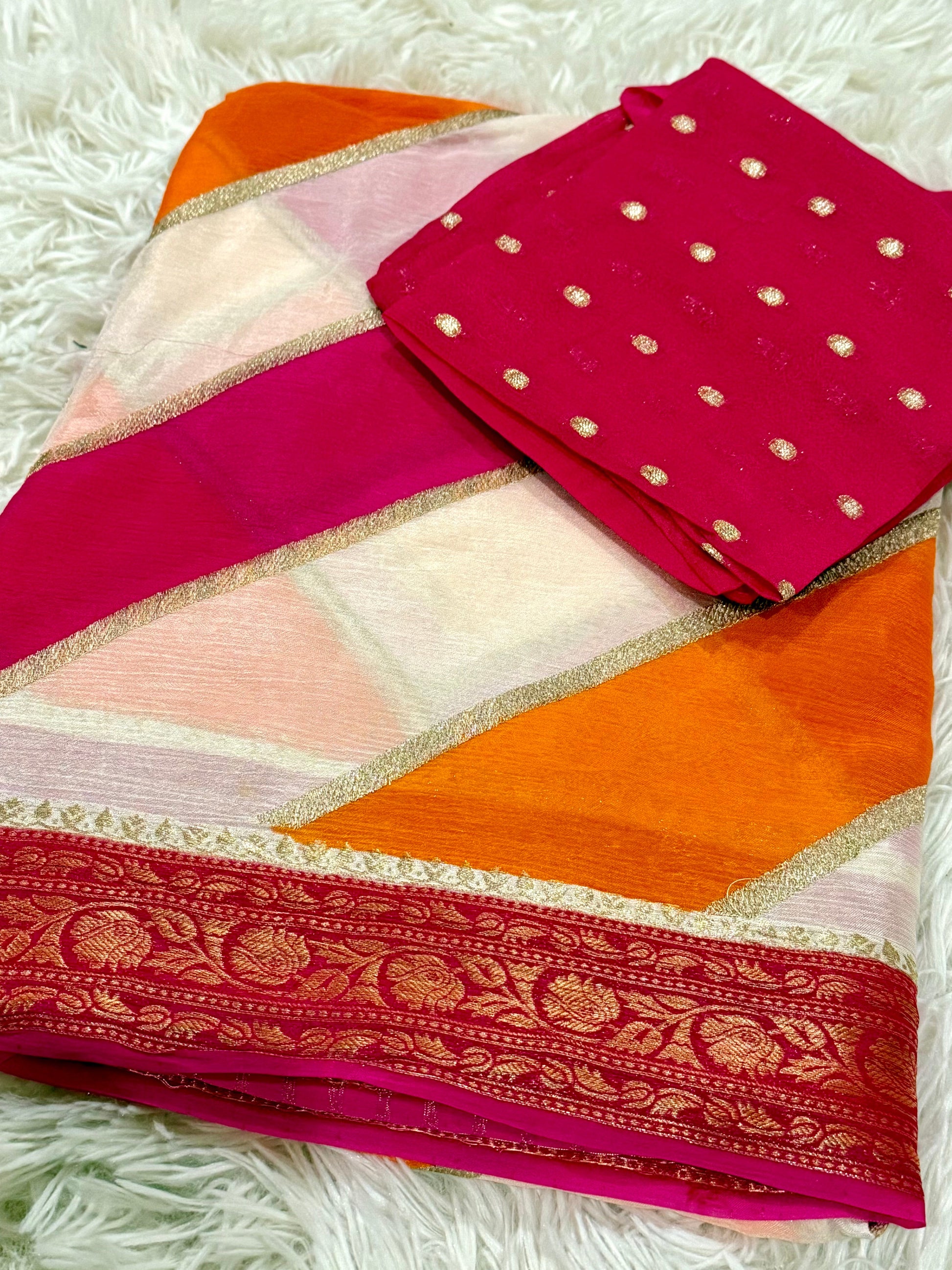 Saree with a pink and orange pattern on a white textured background